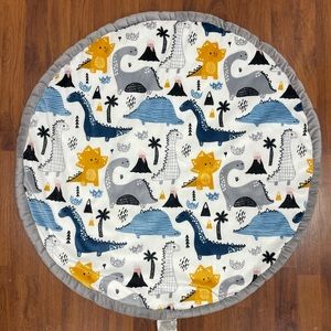 SL Home Fashions round play mat. Dinosaurs tummy mat. Blue checkered back side.
